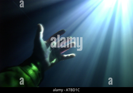 Tendre la main à la main dans un rayon de lumière, la photo par Bruce Miller Banque D'Images