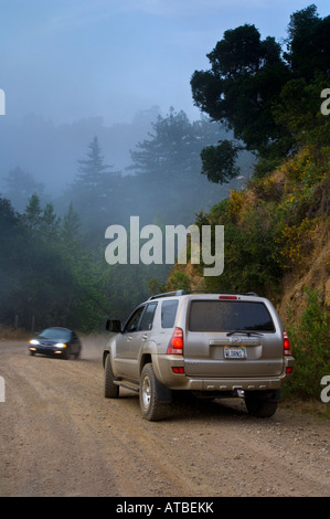 Voiture autour d'un coin passé Toyota 4 Runner 4WD SUV et brouillard côtier le long de la vieille route de terre côte côte de Big Sur Californie Banque D'Images