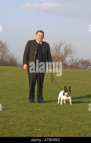 Bouledogue français (Canis lupus f. familiaris), l'homme avec l'homme chien on meadow Banque D'Images