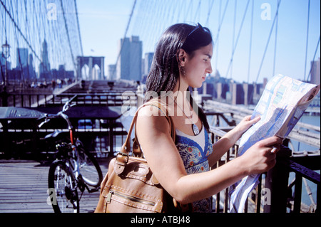 Femme regardant une carte tout en visites sur le pont de Brooklyn, New York City, USA. Banque D'Images