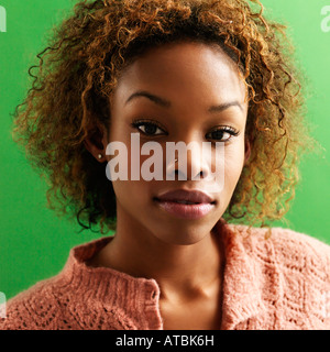 Close up portrait of pretty young woman against green background Banque D'Images