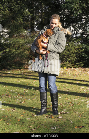 Le Rhodesian Ridgeback (Canis lupus f. familiaris), jeune femme avec huit semaines chiot dans ses bras Banque D'Images