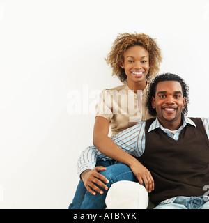 Portrait of happy young couple assis près l'un de l'autre Banque D'Images