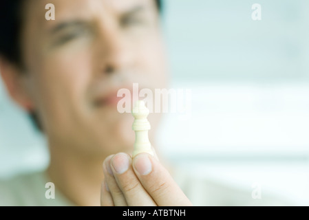 Man holding chess piece, focus on foreground Banque D'Images