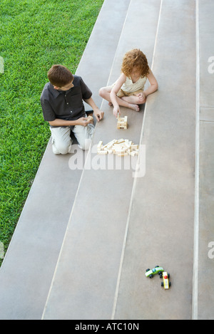 Frère et sœur jouant avec des blocs sur des escaliers, high angle view Banque D'Images