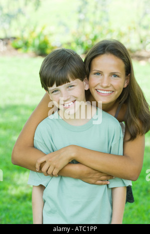 Adolescente et jeune frère smiling at camera, portrait