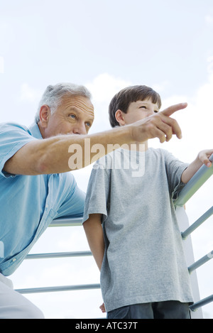 Grand-père et petit-fils par permanent ensemble garde-corps, l'homme, tant à l'écart de pointage Banque D'Images