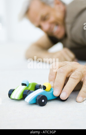 Man Playing with toy cars, low angle view, selective focus Banque D'Images