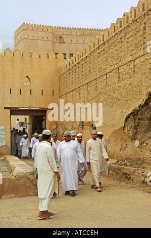 En dishdasha traditionnelle omanaise s'habiller laissant Ar Rustaq fort après la prière Oman Banque D'Images