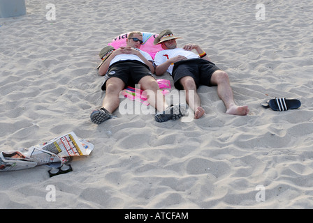 Deux jeunes hommes couchés sur la plage, Majorque, Espagne Banque D'Images