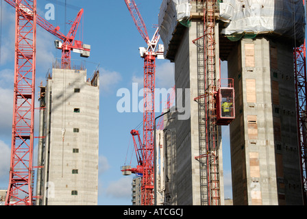 Les grues rouges et des tours en béton contre le ciel bleu Banque D'Images