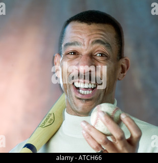 Portrait homme afro-américain souriant et tenant une balle de baseball Banque D'Images