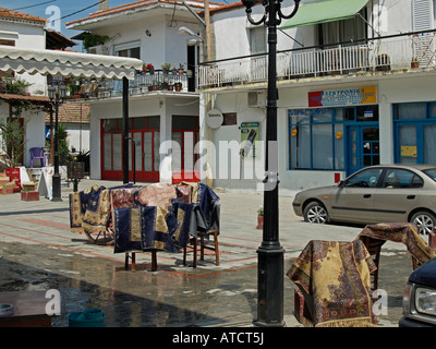 Tapis humides suspendues sur des chaises pour le séchage dans street dans le village grec typique avec des maisons en couleurs blanc Sikia Sithonia Banque D'Images