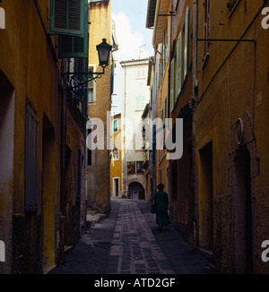 Vue arrière de dame à monter assez typique des rues pavées de la vieille ville rue de Vieille ville de Villefranche-sur-Mer France Banque D'Images