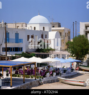 Café en front de mer sur la promenade avec des parasols et des gens à manger Apollon Naxos Island les îles grecques Grèce Banque D'Images