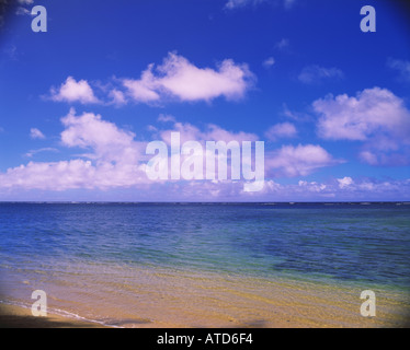 Les nuages blancs moelleux flottent dans un ciel bleu au-dessus de l'eau des Caraïbes Banque D'Images
