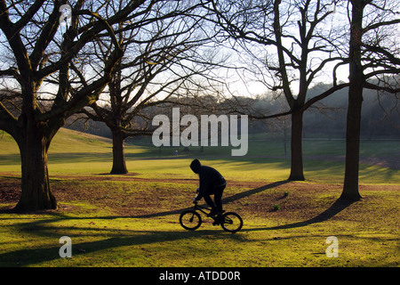 Jeune homme portant hoodie on bicycle in English Park Banque D'Images