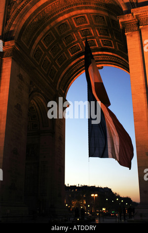 L'énorme drapeau tricolore sous l'Arc de Triomphe sur une soirée d'hiver à Paris France Banque D'Images