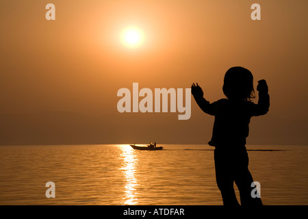 Silhouette d'Girl standing by lake Banque D'Images