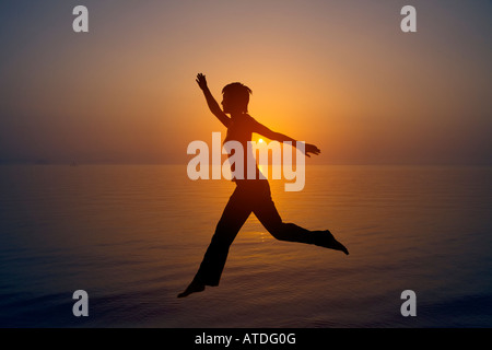 Silhouette of young woman by lake Banque D'Images