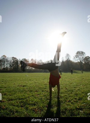 Silhouette d'une jeune femme dans le parc cartwheeling Banque D'Images