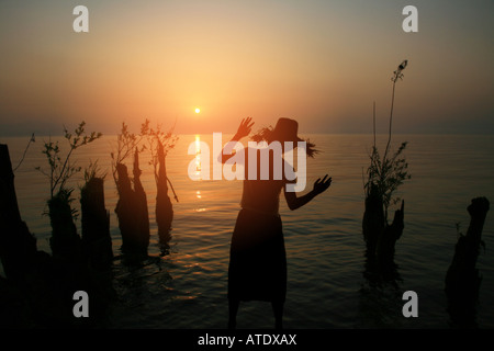 Silhouette of young woman standing by lake Banque D'Images