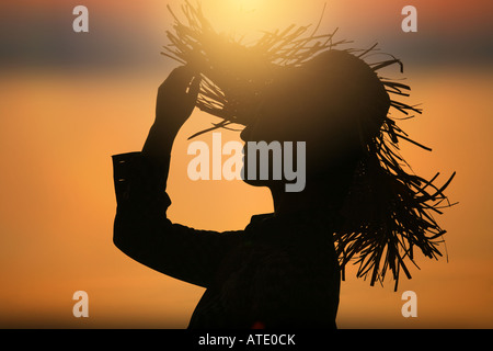 Silhouette of young woman wearing straw hat Banque D'Images