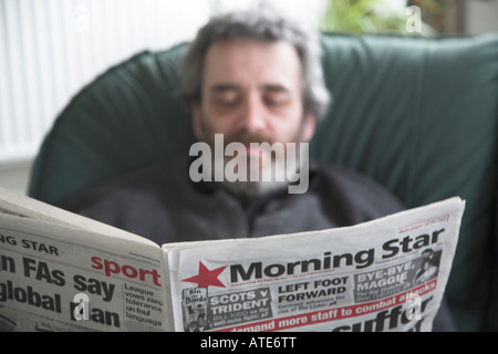 Homme d'âge moyen avec la lecture du journal L'Étoile du Matin de la barbe Banque D'Images