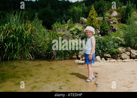 Parc à thème dinosaure, kid sur l'étang Banque D'Images