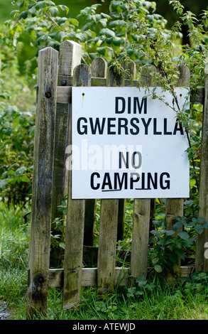 Langue Bilingue Anglais Gallois AUCUN CAMPING inscription joint à la clôture en bois dans village rural de Corris Gwynedd North Wales UK Banque D'Images