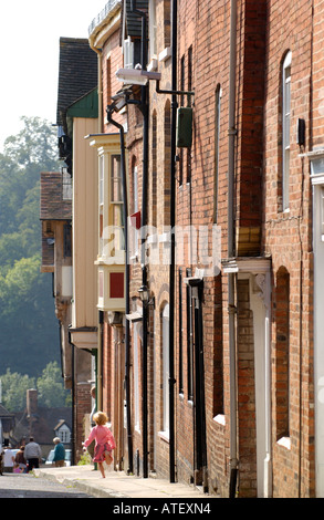 Jeune fille courir dans la rue des terrasses de maisons de ville géorgiennes à Ludlow Shropshire England UK Banque D'Images