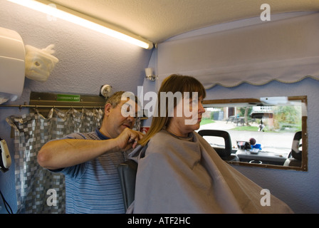 Mobile Barbers intérieur femme ayant ses cheveux coupé intérieur de van dans le parking à Great Horwood, Buckinghamshire Angleterre des années 2006 2000 UK HOMER SYKES Banque D'Images