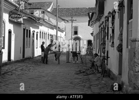 Scène de rue animée people socializing siéger porte peinture artistes Paraty Rio de Janeiro Brésil Brasil Amérique Latine du Sud Banque D'Images