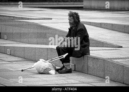 Homme sénile barbu avec sac et s'accroupit siéger seul solitaire sur shining en marbre pas de monument Tokyo Japon Asie Orientale Banque D'Images