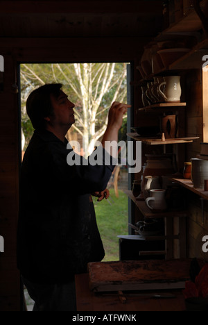 Potter surveys his wares in silhouette Banque D'Images