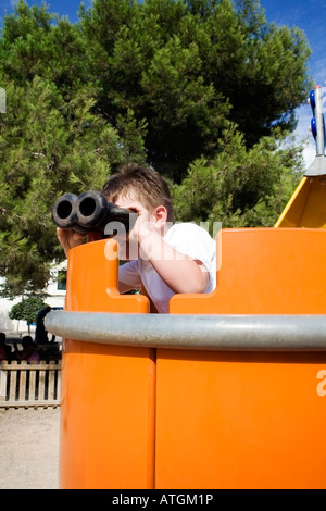 Boy looking through binoculars Banque D'Images