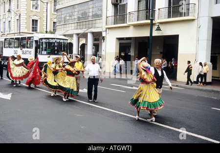 Procession de gens portant des vêtements de couleur vive, en dansant dans la rue. Guayaquil. L'Équateur. Banque D'Images
