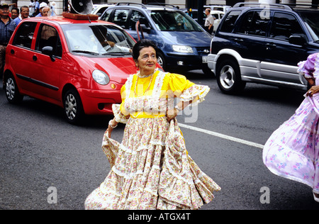 Procession de gens portant des vêtements de couleur vive, en dansant dans les rues de Quito. L'Équateur. Banque D'Images