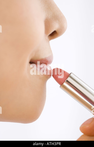 Young woman applying lipstick Banque D'Images