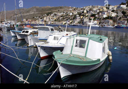 Peu de bateaux de pêche bob dans le paisible port sur l'île de Symi Grèce Banque D'Images