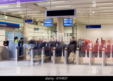 Les passagers en passant par les barrières automatique de billets à St Pancras, Londres, Angleterre. Banque D'Images