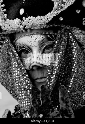 Portrait noir et blanc d'une femme âgée habillés en costume et masque prenant part à la Carnaval de Venise Vénétie Italie Banque D'Images