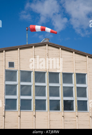 Une chaussette rouge et blanche contre le ciel bleu sur le toit du hangar, en Finlande Banque D'Images