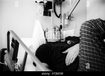 Grand homme chauve en lit d'hôpital a un fou rire. Banque D'Images