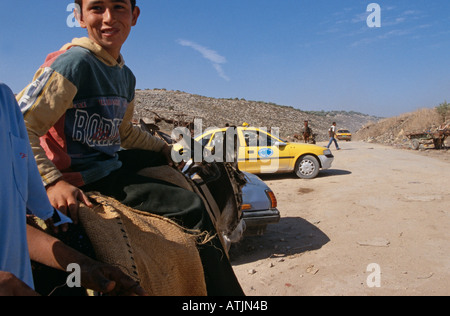 Un garçon sur son âne sur la route à Tulkarem Cisjordanie Banque D'Images