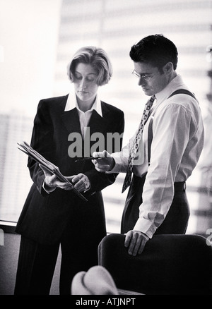 Businesspeople looking at papers in office B W soft focus Banque D'Images