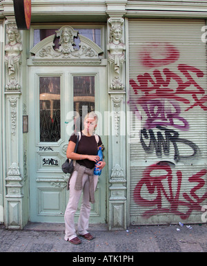 Femme unique à l'extérieur d'un touristiques couvertes de graffiti Shop à Prague' Banque D'Images