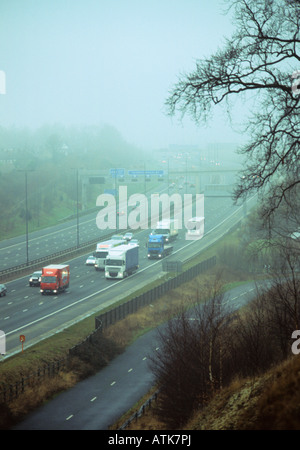 Traffic voyager dans l'épais brouillard sur l'A1 autoroute M1 Leeds Yorkshire UK Banque D'Images