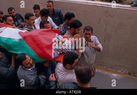 Un groupe d'hommes portant un corps enveloppé dans le drapeau de la Palestine Banque D'Images