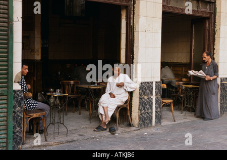 Les hommes de détente à ouvrir la porte d'un café. Le Caire, Égypte. Banque D'Images